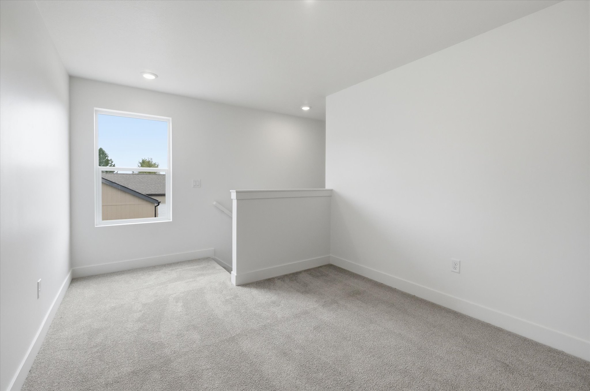 Carpeted room featuring a single window with white trim, white walls, and recessed lighting