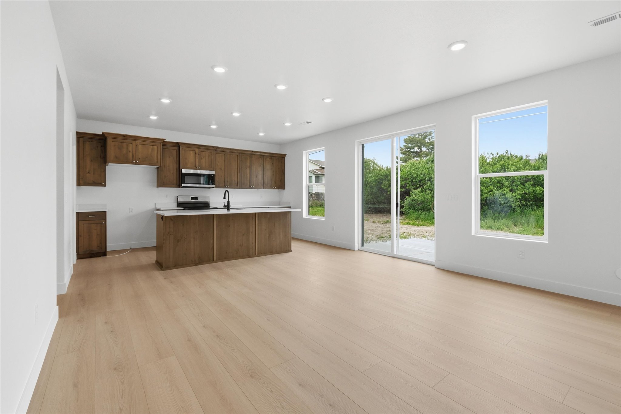 Open-concept living space featuring wood-finish flooring and recessed lighting