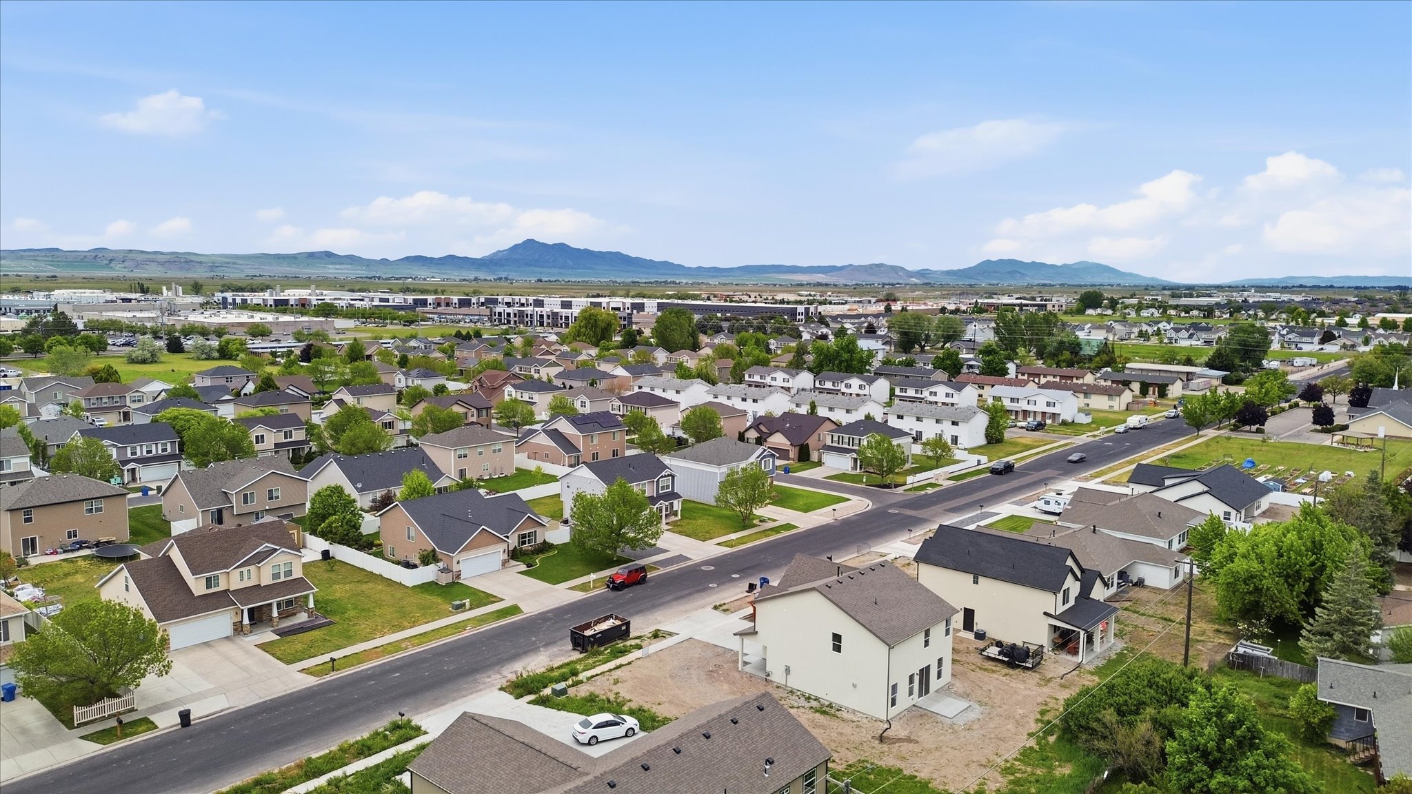 Aerial perspective of a residential neighborhood featuring single-family homes with pitched roofs