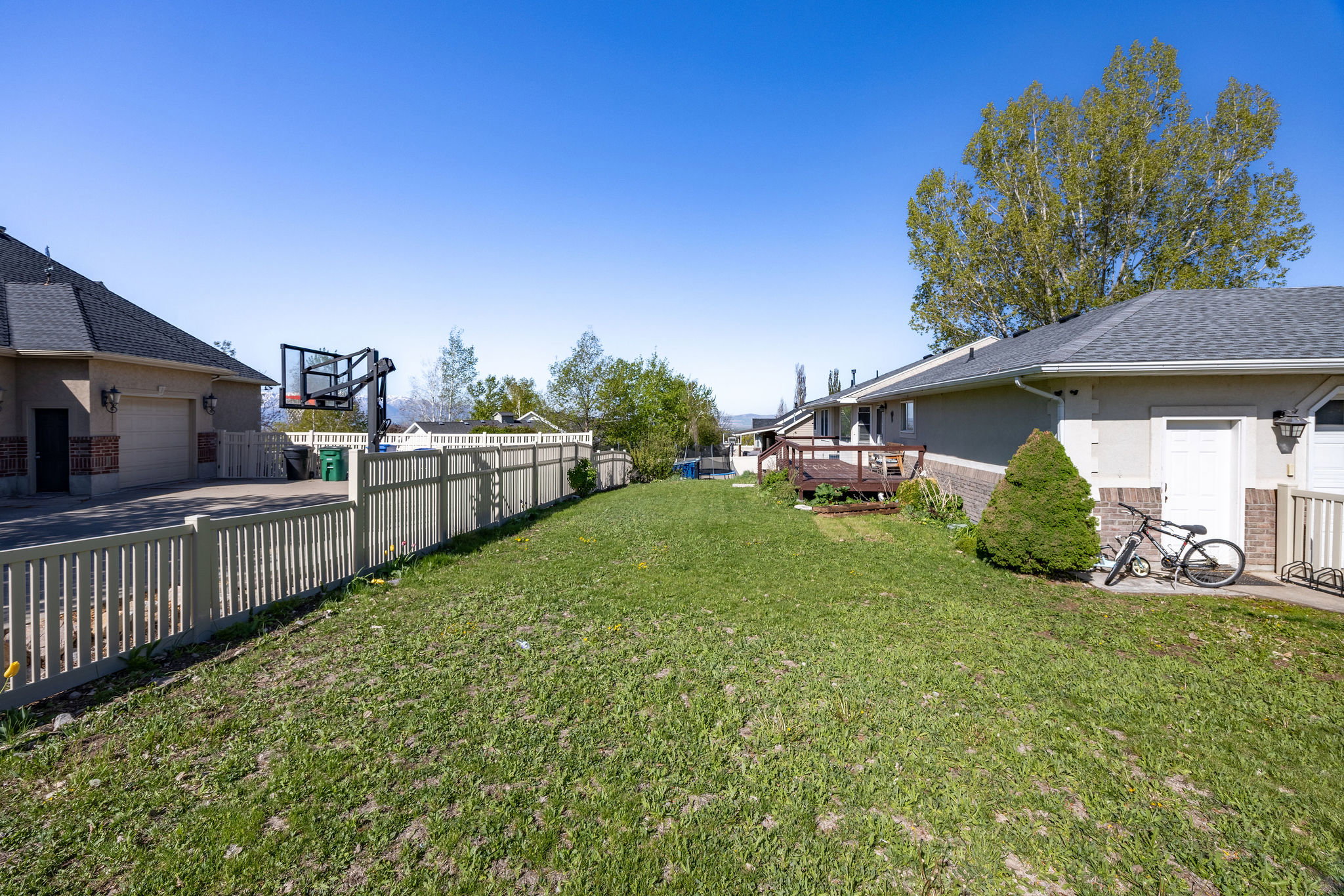 Fenced backyard with a wooden deck and a garage