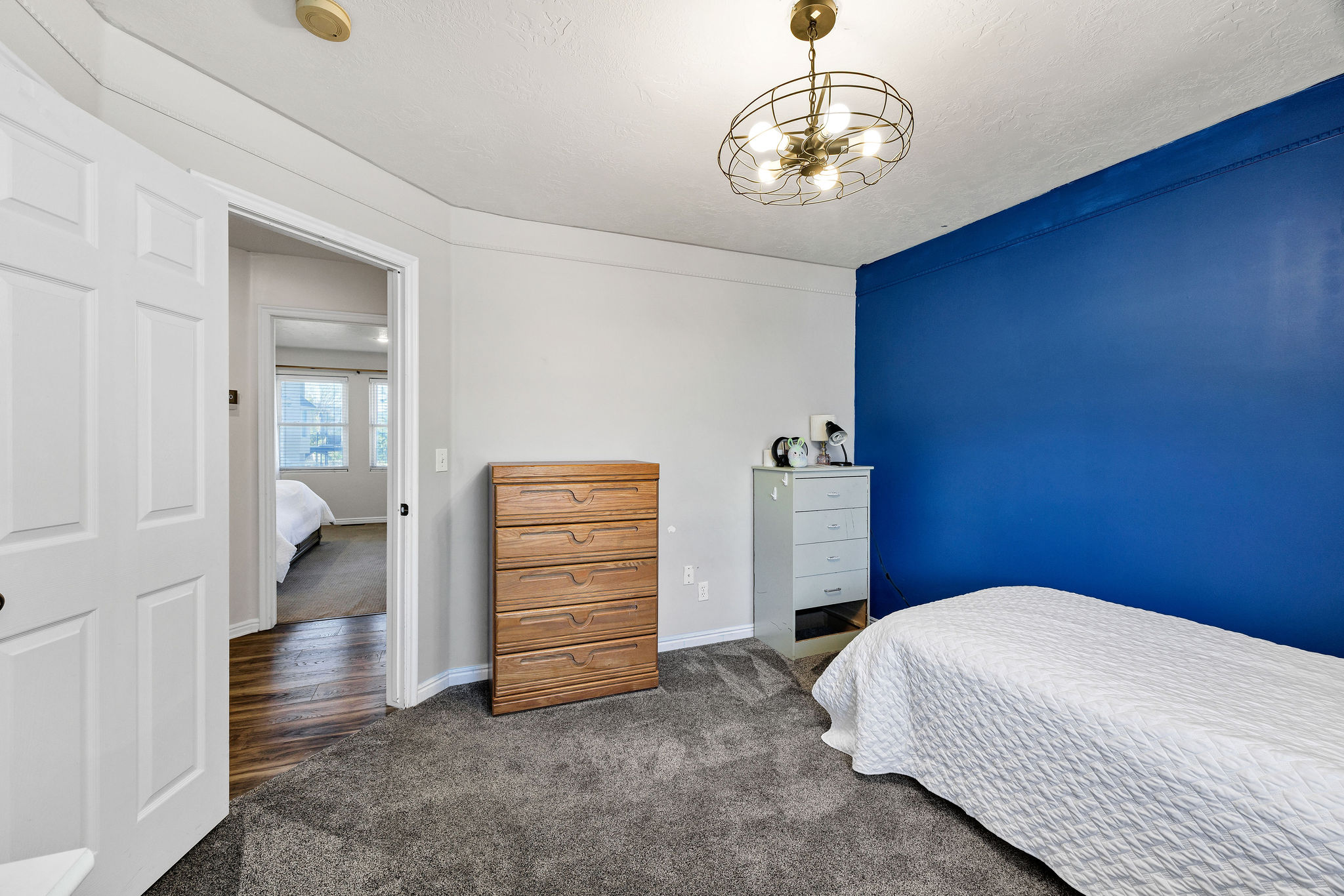 Bedroom featuring dark colored carpet and suspended lighting