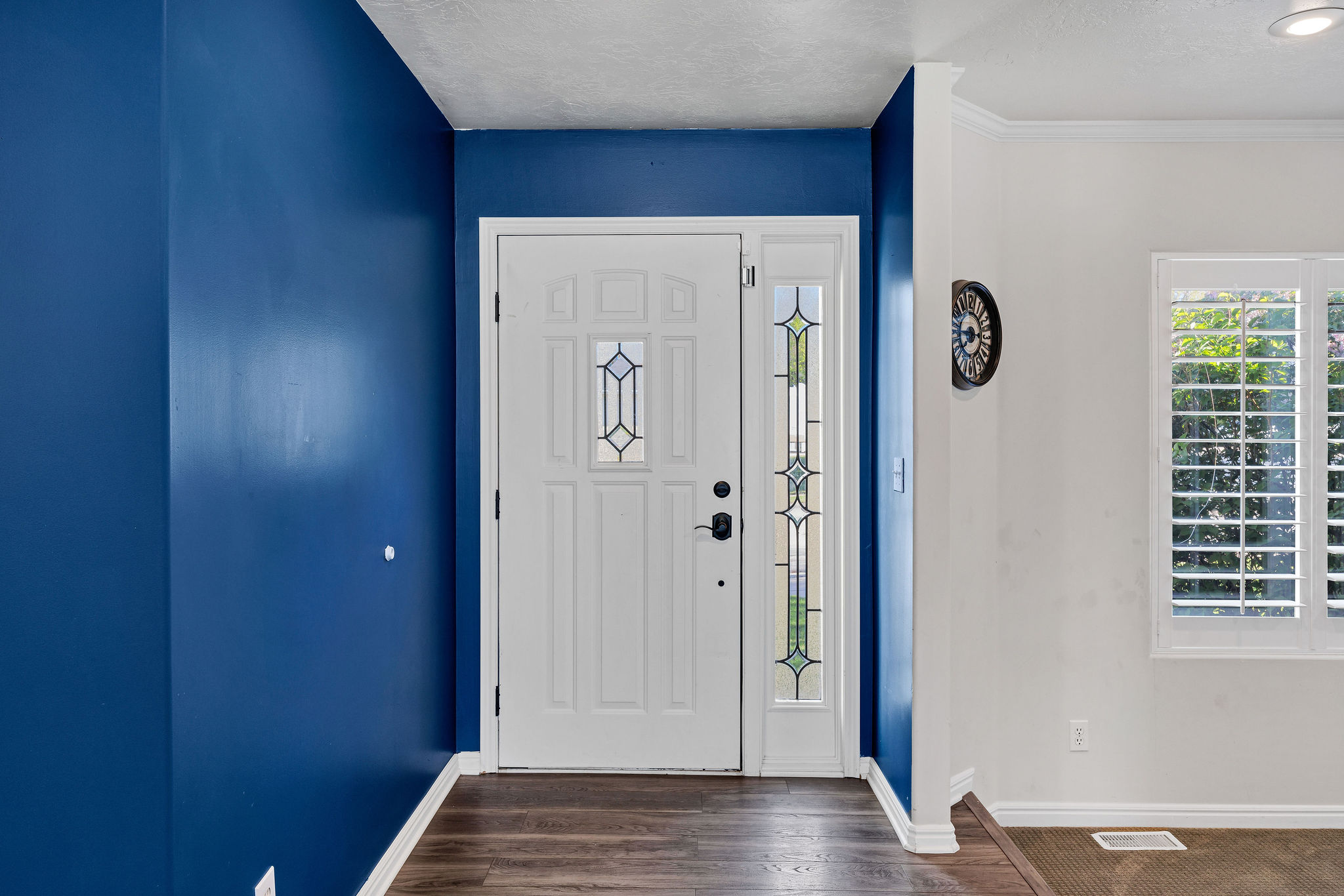 Foyer entrance with dark wood-style floors, plenty of natural light, and a textured ceiling
