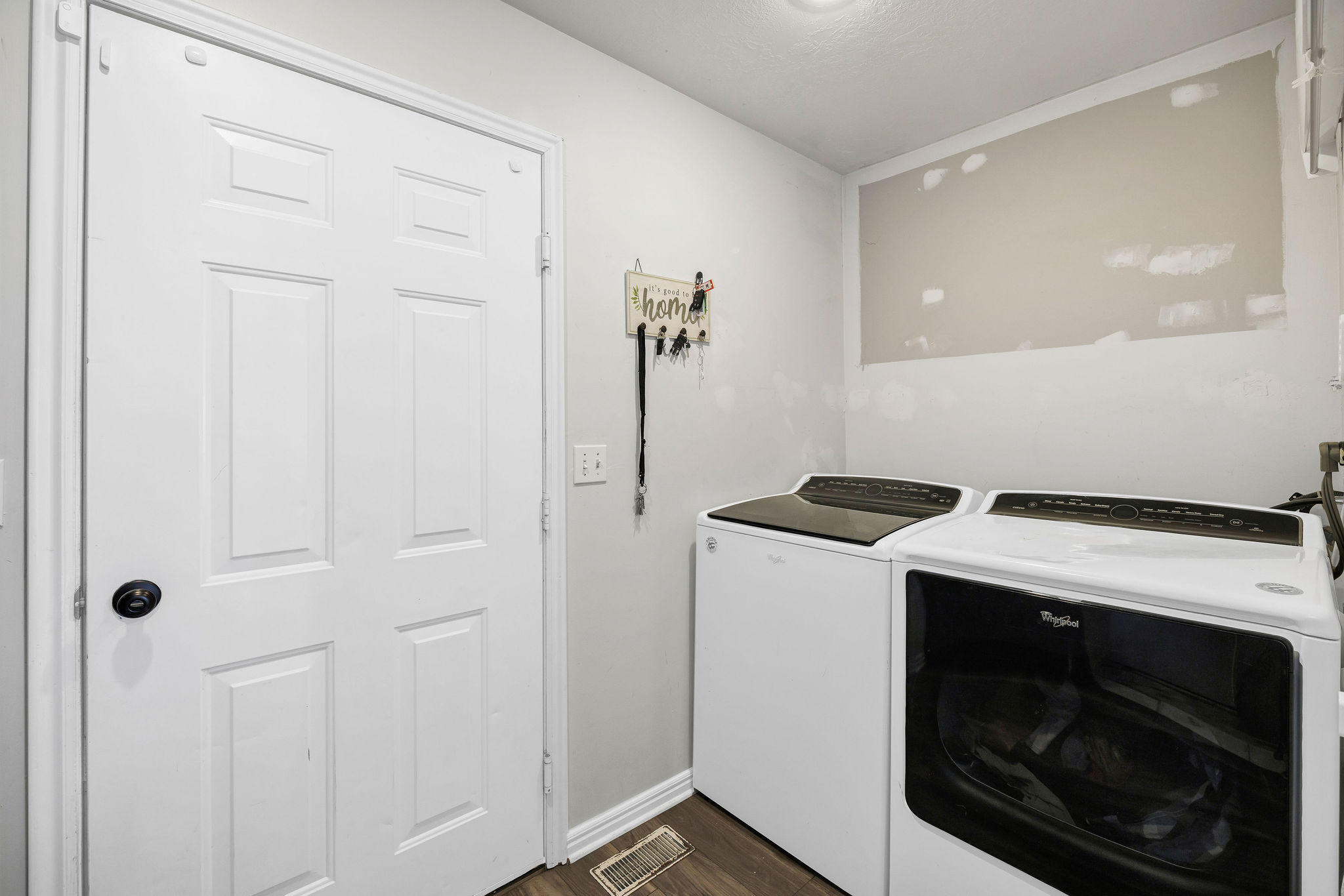 Laundry room featuring independent washer and dryer and dark wood finished floors