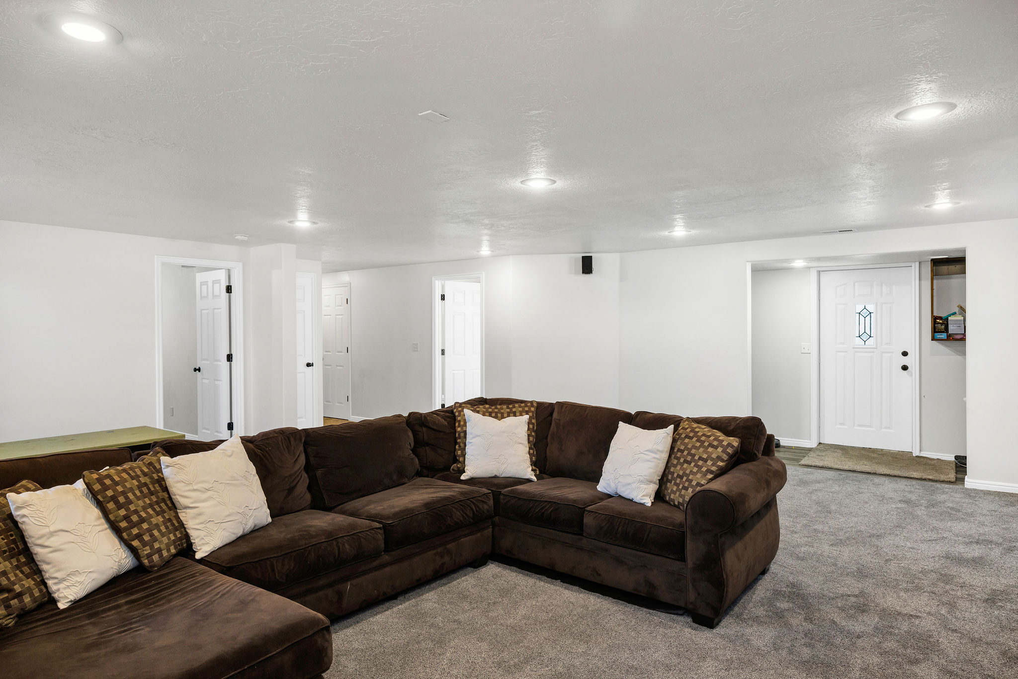 Basement Living room with a textured ceiling and carpet flooring