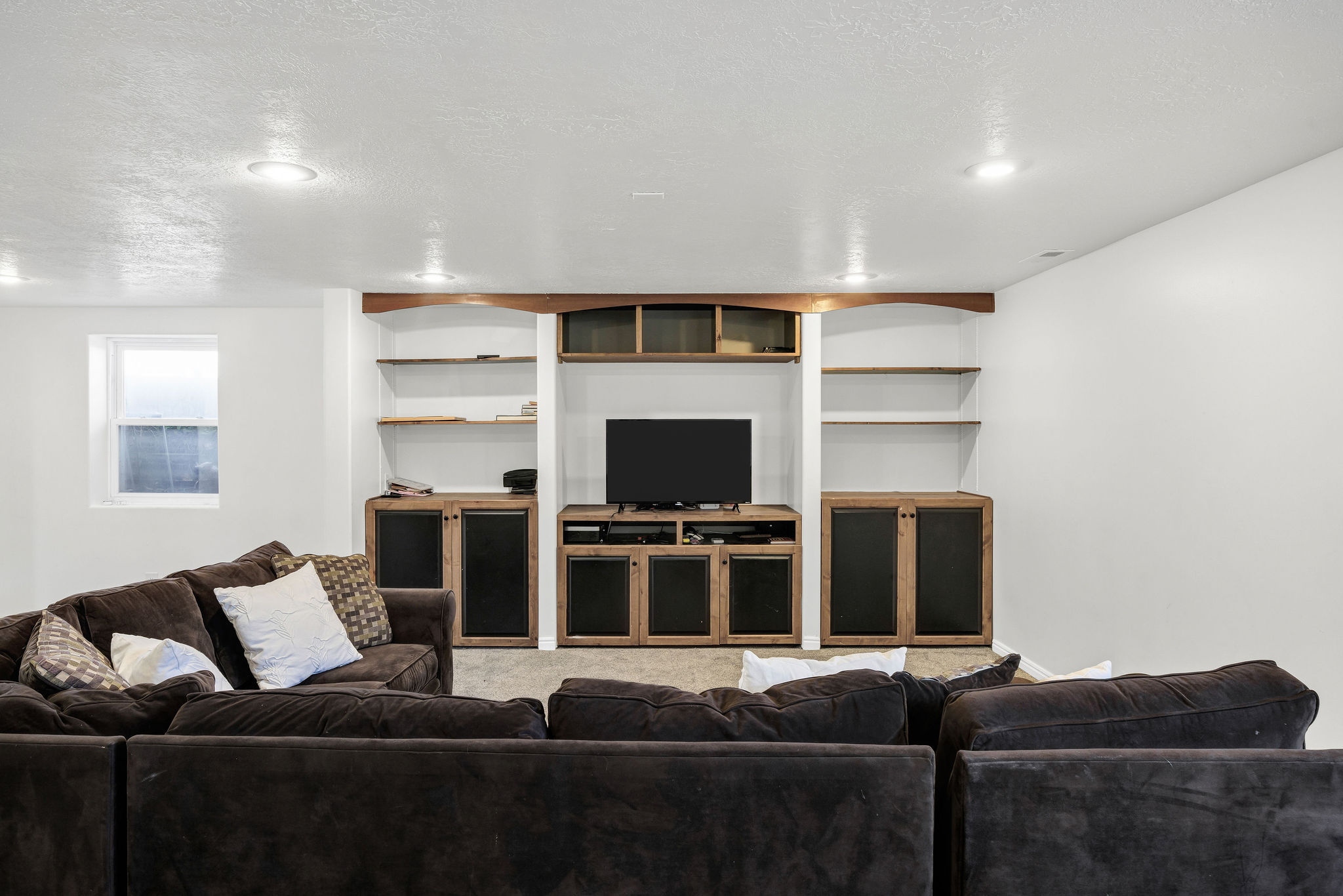 Basement Living room with a textured ceiling and carpet flooring