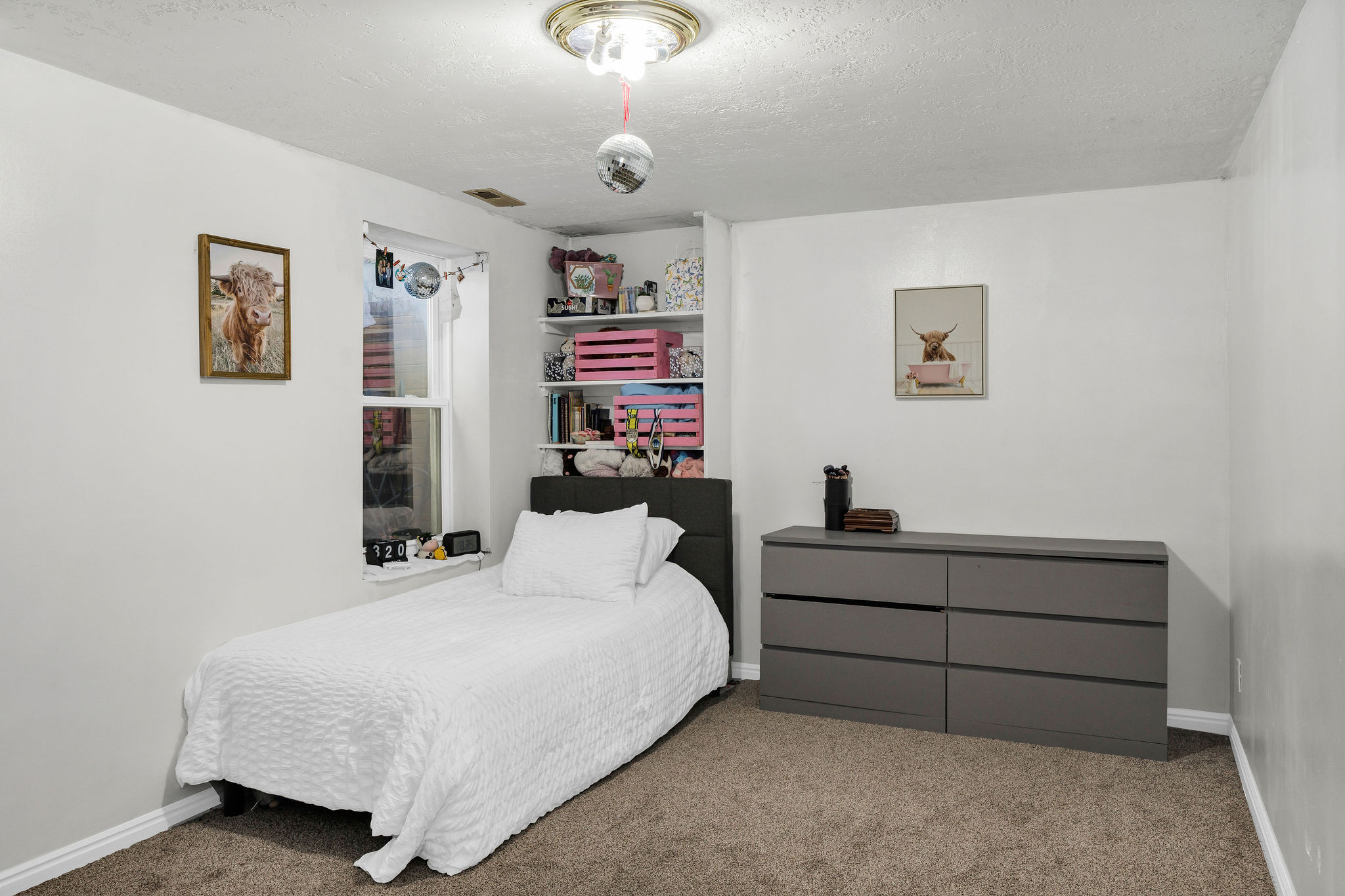 Carpeted bedroom featuring a textured ceiling and baseboards