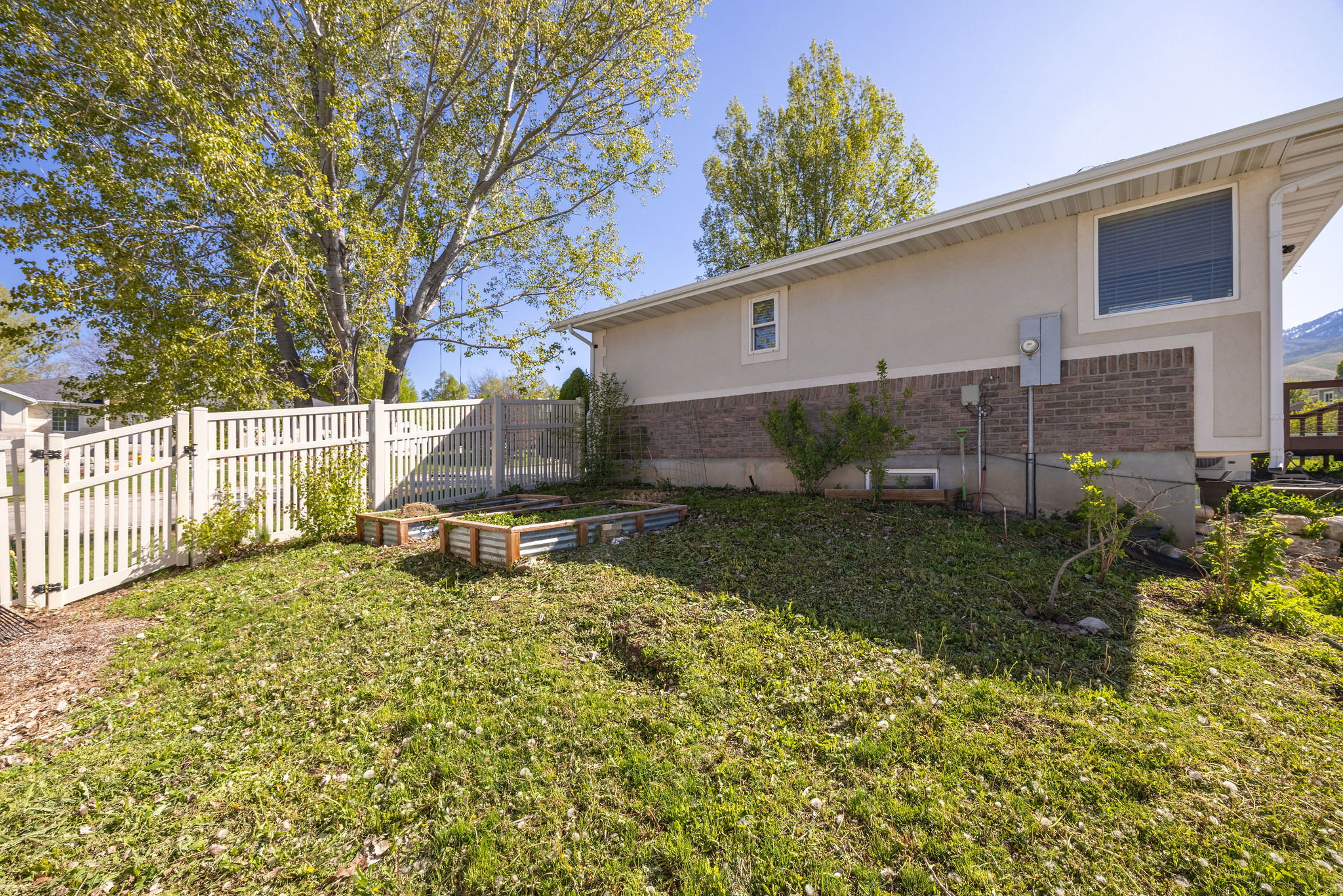 Fenced backyard featuring a vegetable garden