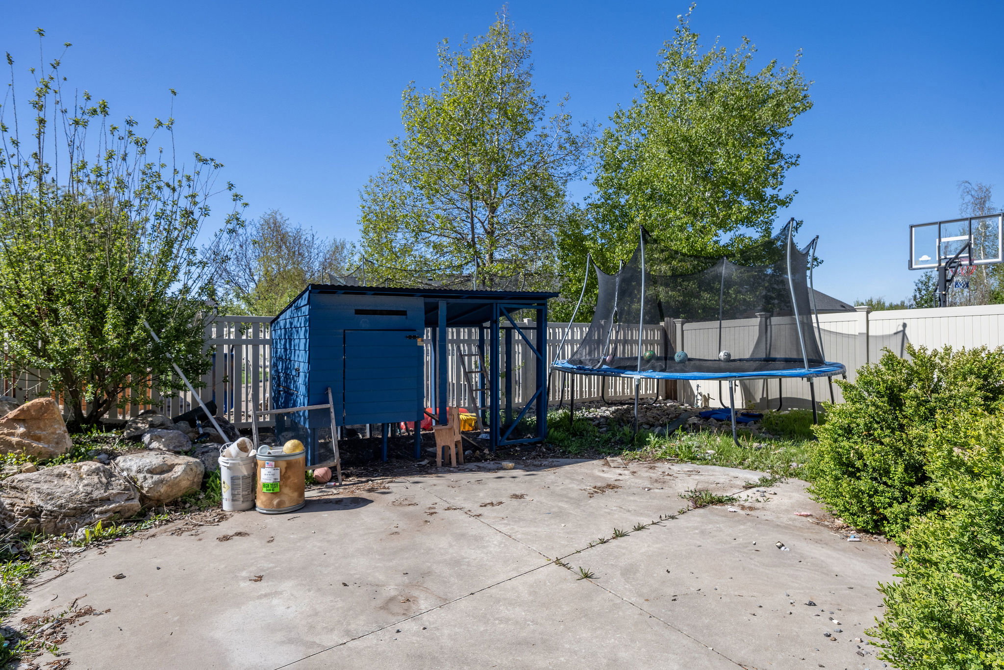 Fenced backyard featuring a storage shed and a trampoline