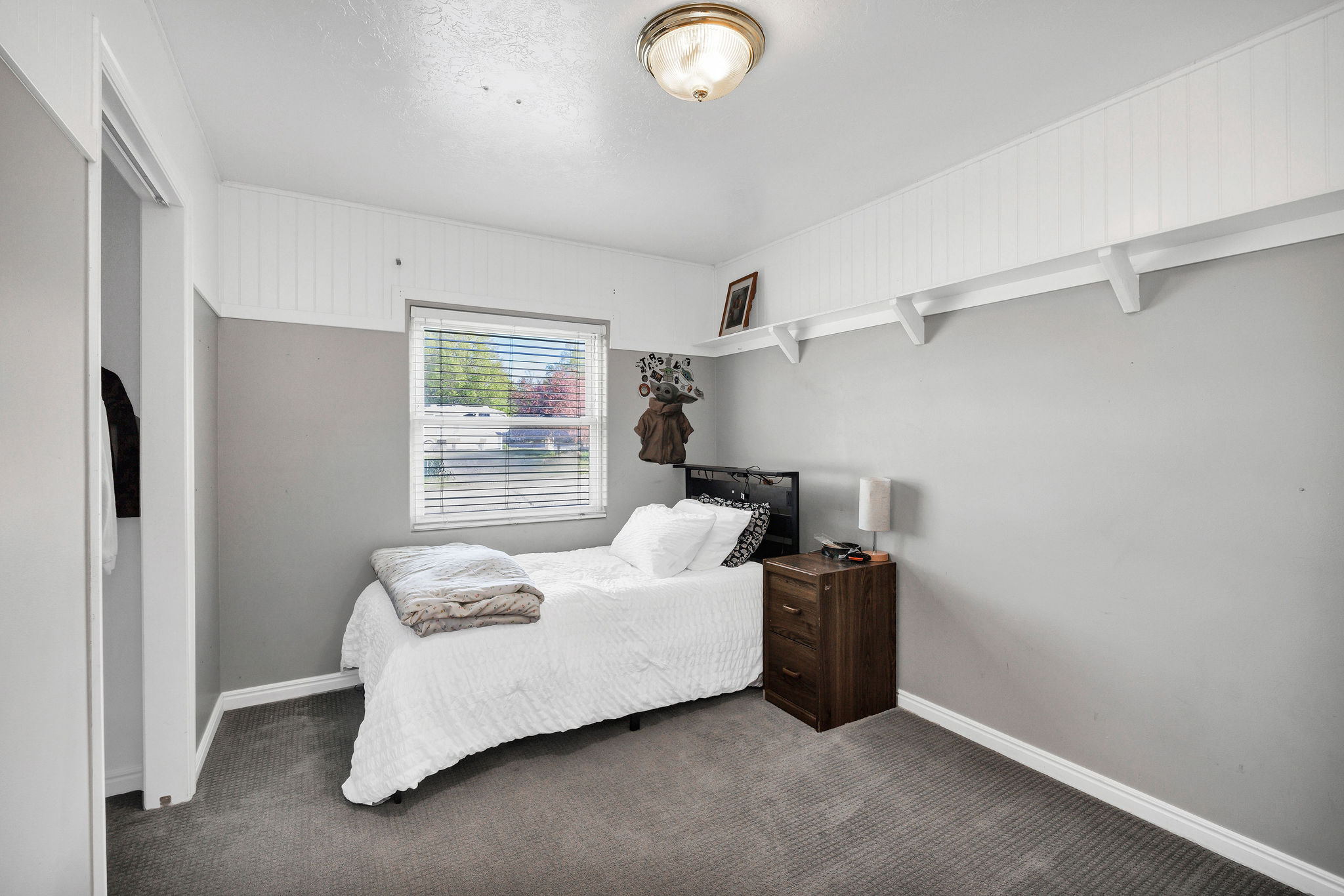 Bedroom with dark colored carpet and baseboards