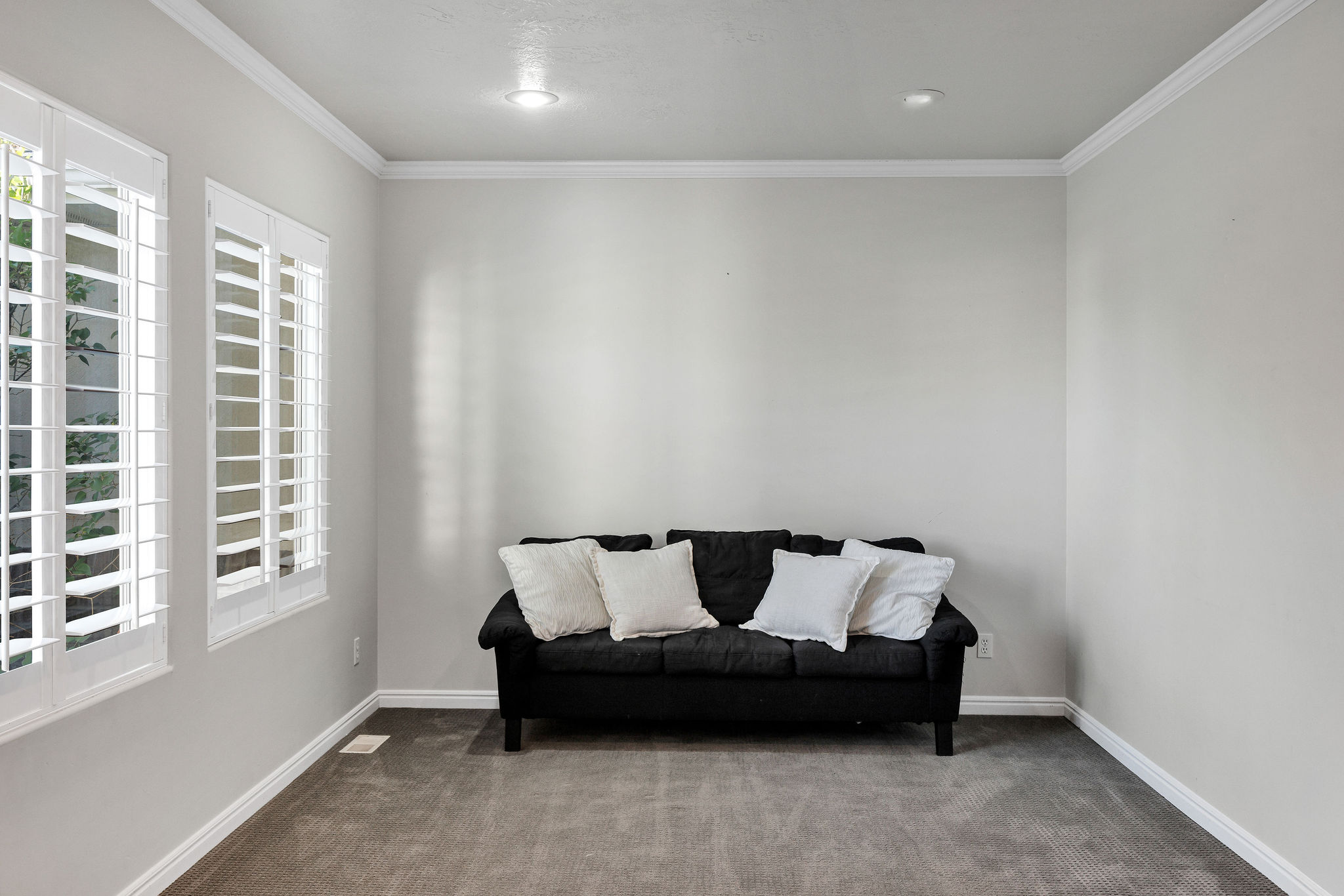 Front sitting room with crown molding, shutters and carpet floors