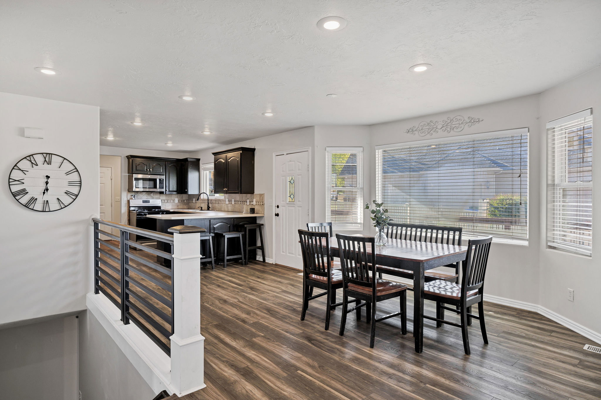 Dining room with dark wood-style floors and recessed lighting