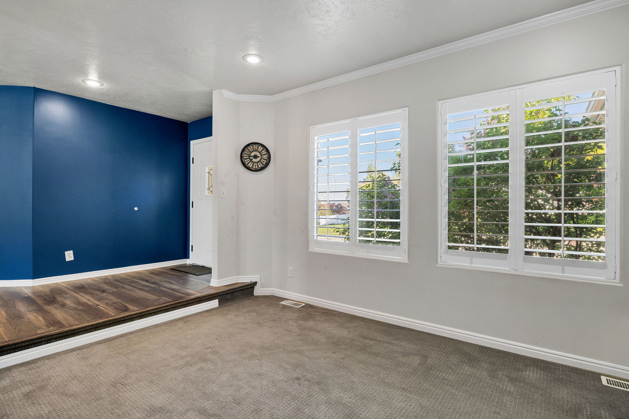 Unfurnished rront living room with baseboards and dark carpet
