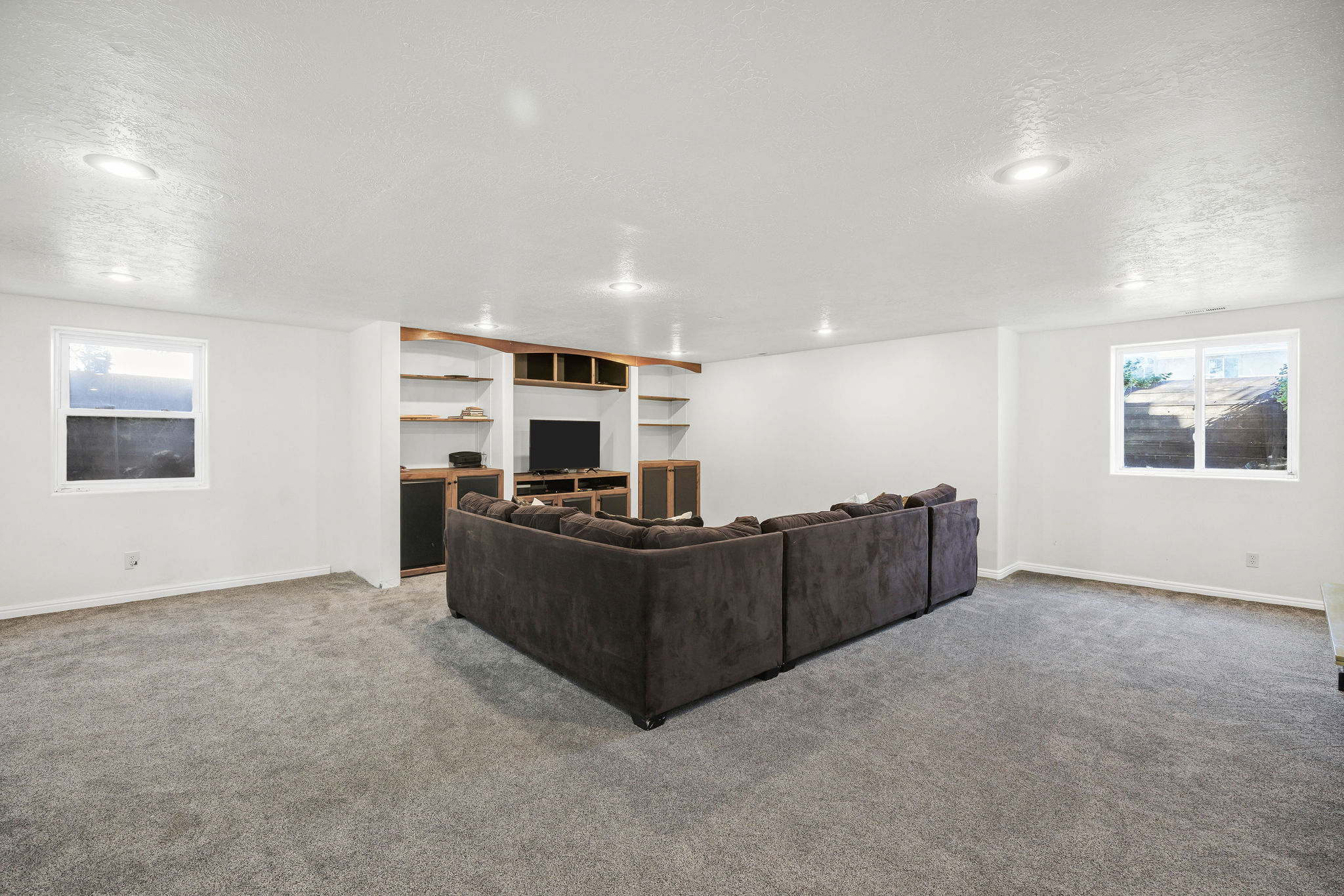 Basement Living room with healthy amount of natural light, carpet flooring, and a textured ceiling