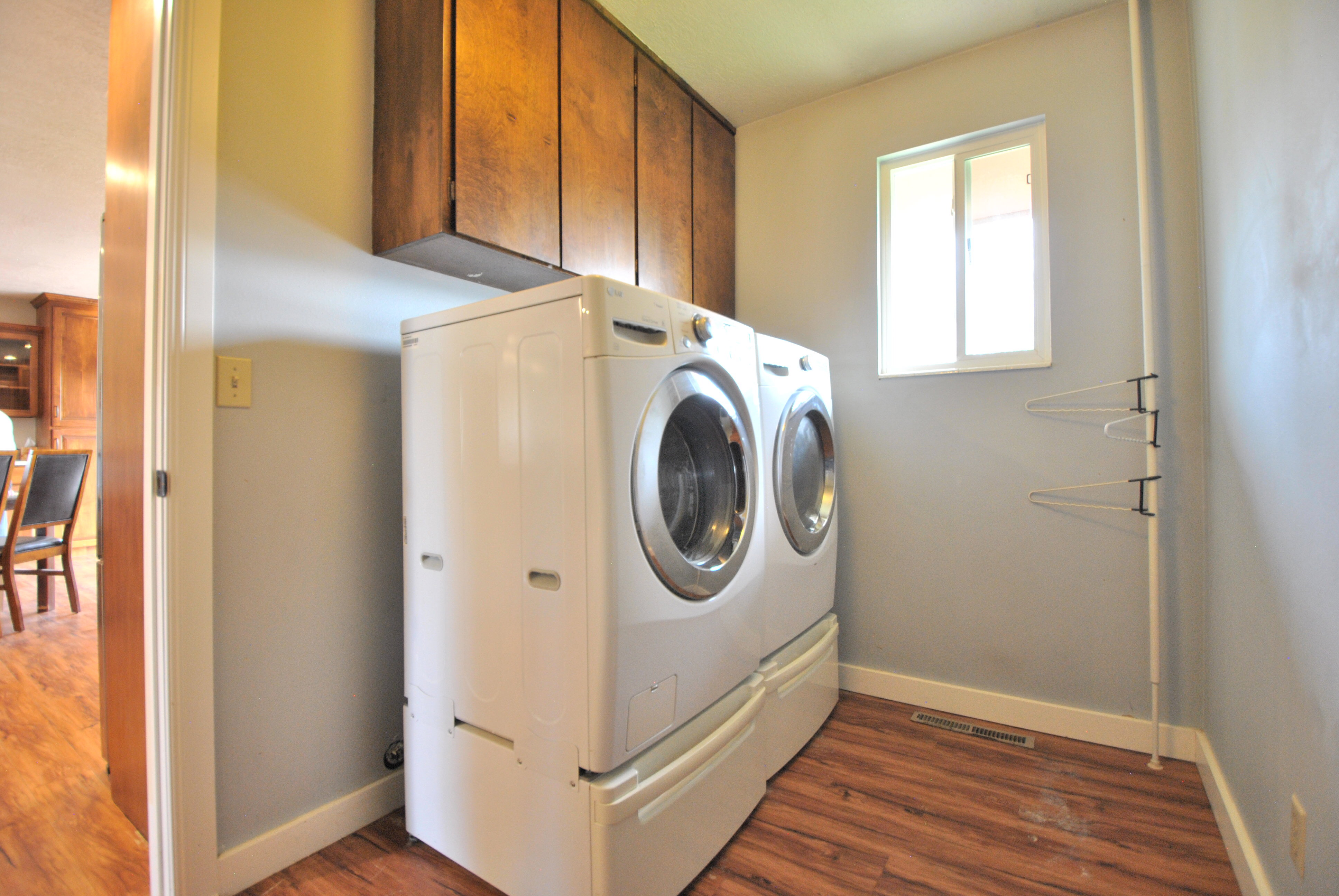 Laundry room featuring dark wood-style floors, separate washer and dryer, and cabinet space