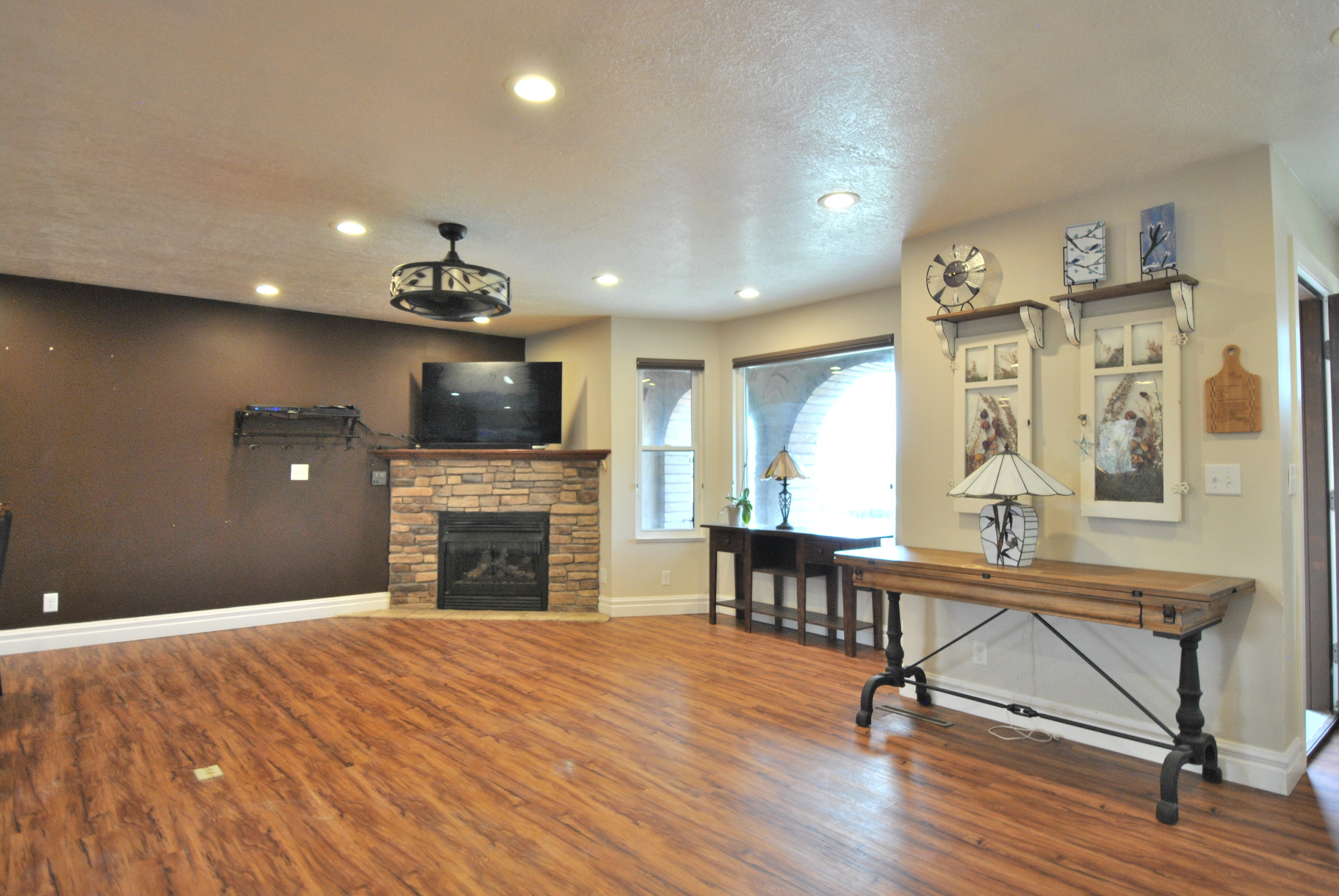 Living room featuring wood finished floors, a fireplace, recessed lighting, and a textured ceiling