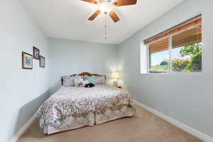 Bedroom featuring light carpet and a ceiling fan