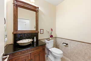 Bathroom featuring vanity, tile walls, and wainscoting