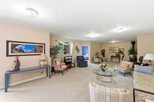 Living area with light carpet and baseboards
