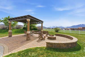 Fenced backyard with a mountain view, a fire pit, and a patio