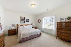 Bedroom featuring light carpet