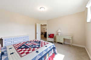 Bedroom featuring light colored carpet and baseboards