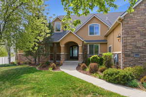View of front of house featuring stone siding and stucco siding