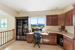 Office with light wood-type flooring and built in desk