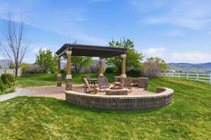 View of yard featuring a mountain view, a patio, an outdoor fire pit, and a pergola