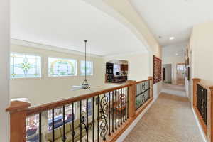 Corridor featuring light colored carpet, plenty of natural light, and recessed lighting