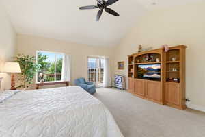 Bedroom with access to exterior, lofted ceiling, light colored carpet, and a ceiling fan