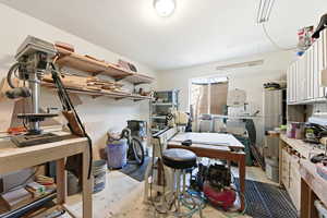 Miscellaneous room featuring unfinished concrete floors and a workshop area