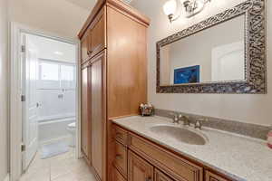 Bathroom featuring vanity, light tile patterned floors, and shower / washtub combination