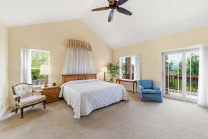 Carpeted bedroom featuring access to exterior, a high ceiling, and ceiling fan