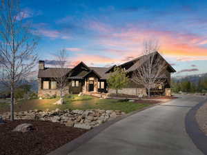 Craftsman inspired home with stone siding, board and batten siding, a front lawn, and a chimney