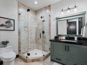 Full bathroom with vanity, a shower stall, and recessed lighting