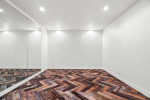 Spare room featuring parquet floors and recessed lighting