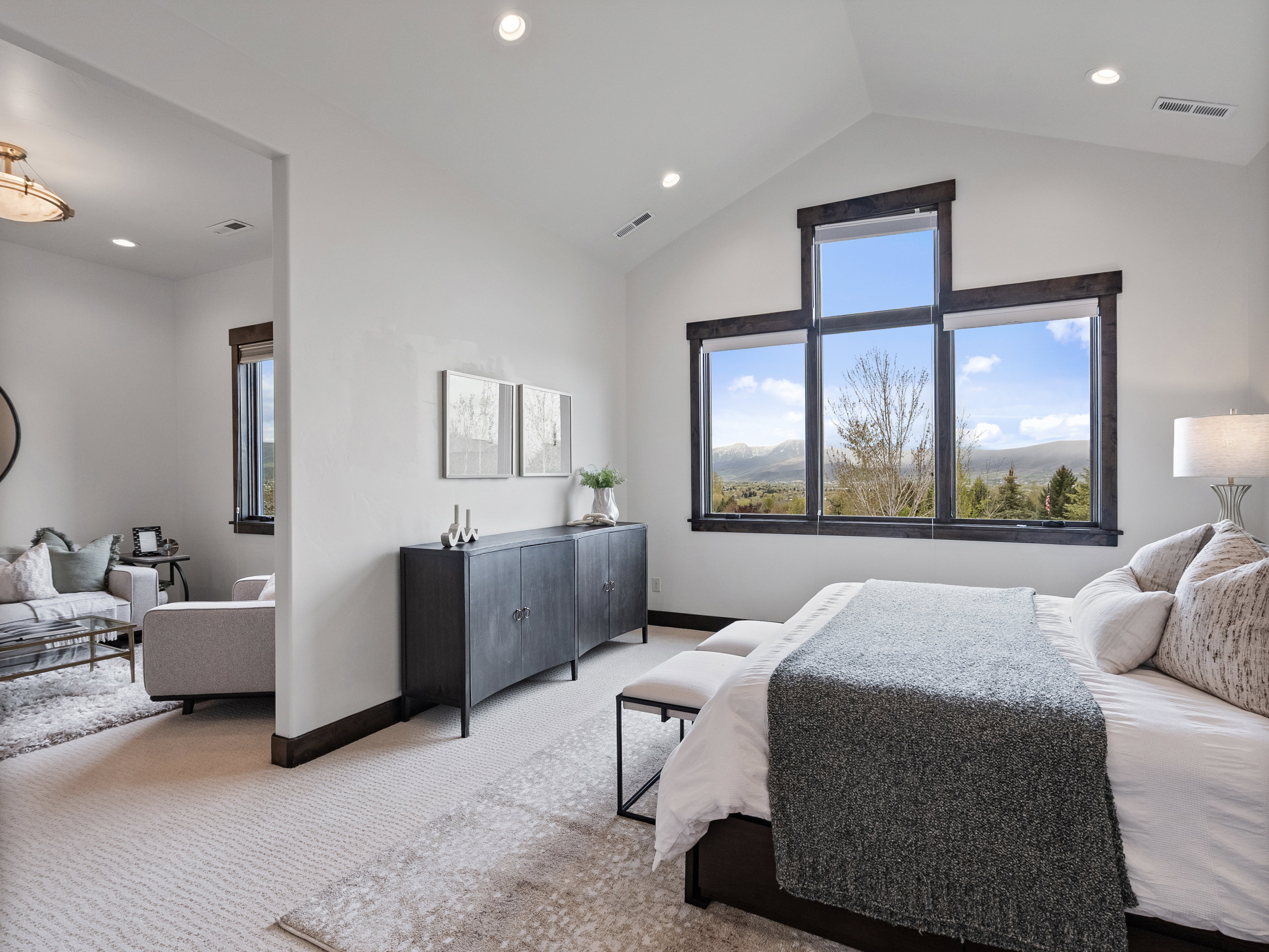 Carpeted bedroom with a high ceiling and recessed lighting