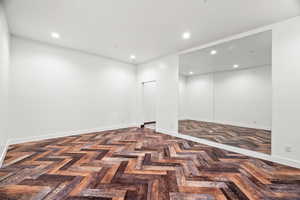 Spare room featuring parquet floors and recessed lighting