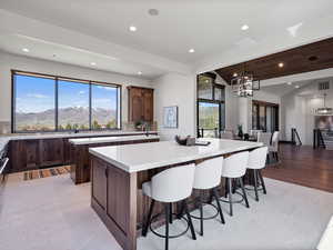 Kitchen featuring decorative backsplash, a large island, a kitchen breakfast bar, a mountain view, and lofted ceiling