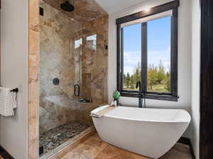 Full bathroom featuring a shower stall and a soaking tub