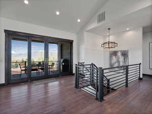 Stairs with hardwood / wood-style flooring, a mountain view, a high ceiling, and a chandelier