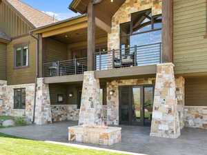 View of exterior entry with stone siding, a patio area, and french doors