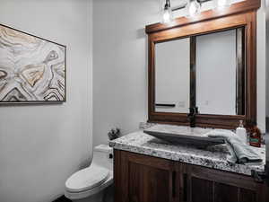 Half bathroom featuring vanity and toilet
