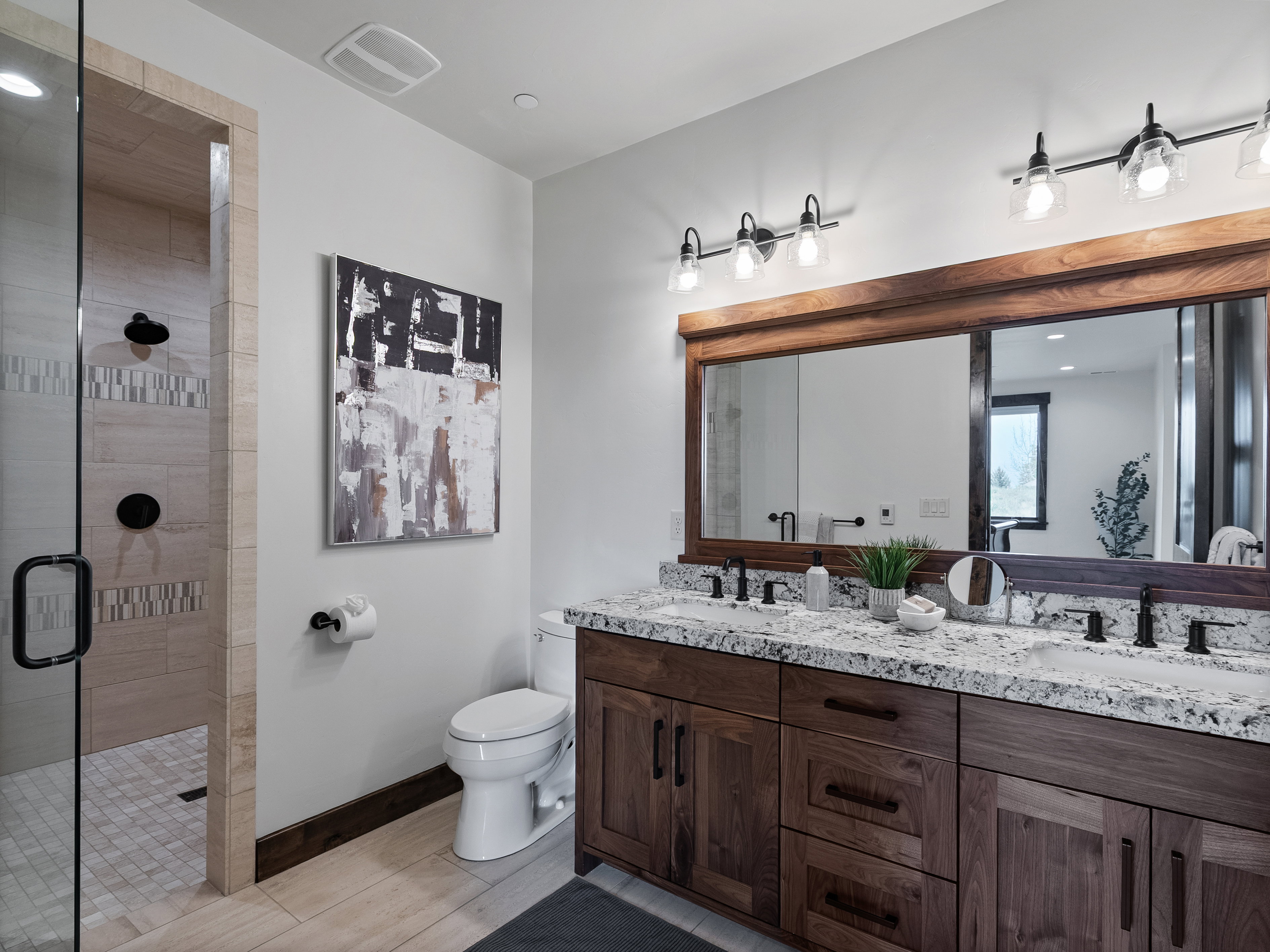 Bathroom featuring double vanity and a shower stall
