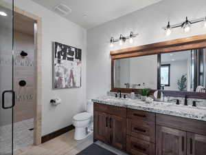 Bathroom featuring double vanity and a shower stall