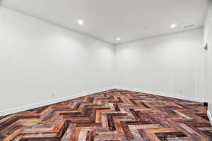 Spare room with parquet flooring and recessed lighting