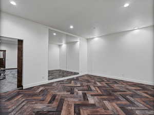 Spare room with parquet flooring and recessed lighting