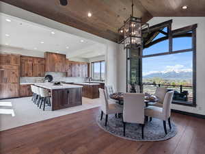 Dining area featuring a mountain view, a high wood ceiling, light wood finished floors, and suspended lighting
