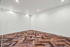 Spare room featuring recessed lighting and parquet floors
