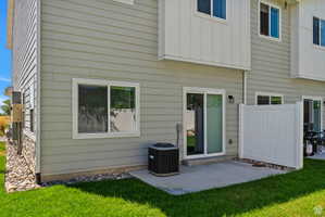 Back of house featuring board and batten siding, a lawn, and a patio area